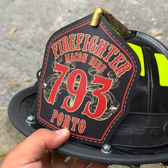 Firefighter metal helmet shield with large numbers and flourishes in the background
